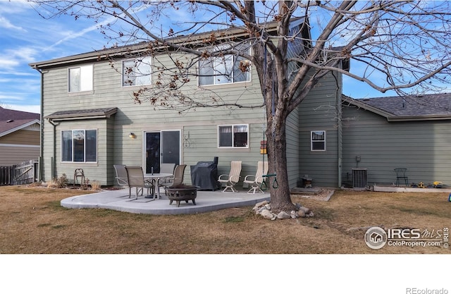 rear view of property with a yard, an outdoor fire pit, a patio area, and central air condition unit