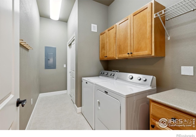 washroom with washing machine and dryer, cabinets, and electric panel