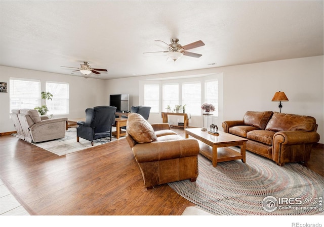 living area with plenty of natural light, a ceiling fan, and wood finished floors