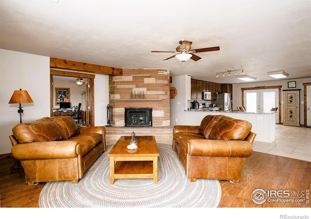 living room featuring light wood-type flooring, ceiling fan, a textured ceiling, and track lighting