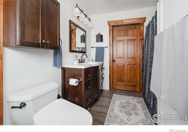 bathroom with vanity, toilet, and wood finished floors