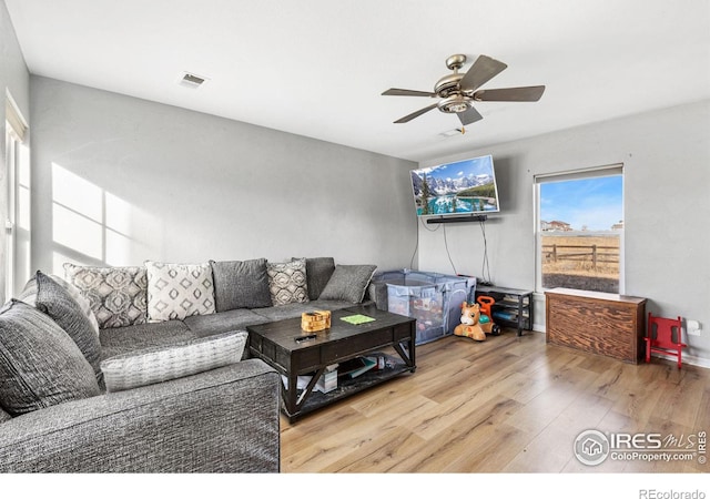 living room with ceiling fan and light wood-type flooring