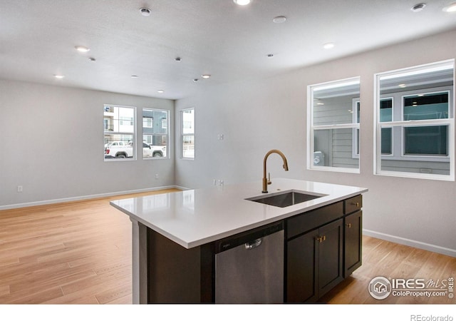 kitchen featuring sink, light hardwood / wood-style flooring, dark brown cabinetry, an island with sink, and stainless steel dishwasher