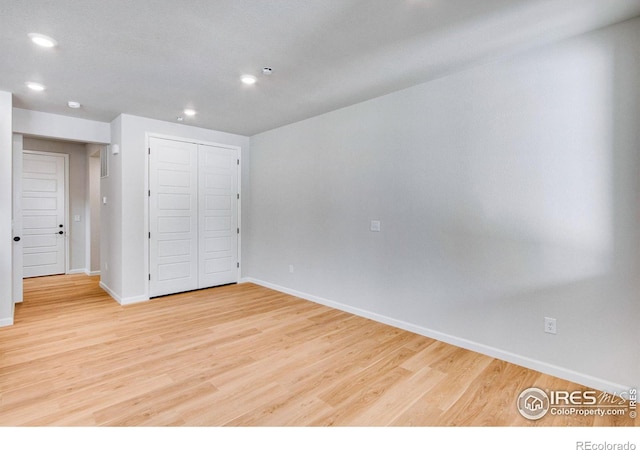 unfurnished bedroom featuring light hardwood / wood-style floors and a closet