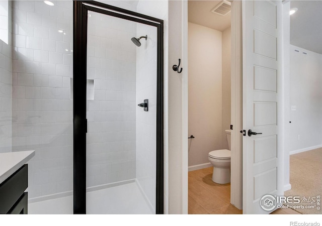 bathroom with vanity, toilet, and tiled shower