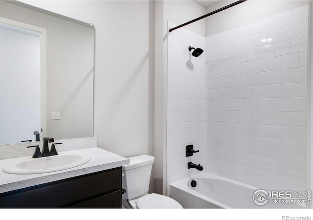 full bathroom with tiled shower / bath, vanity, and toilet