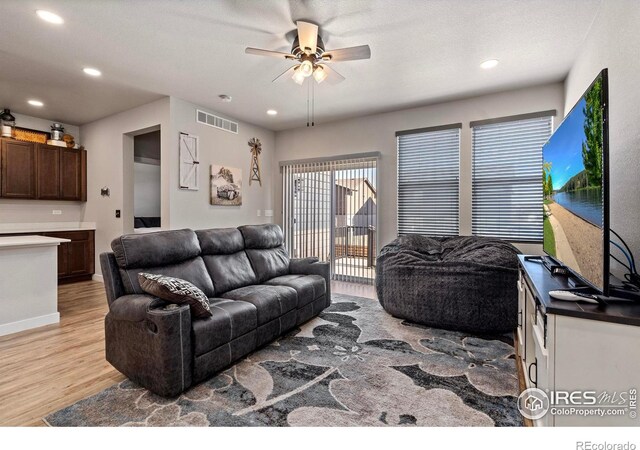 living room featuring ceiling fan and light hardwood / wood-style flooring