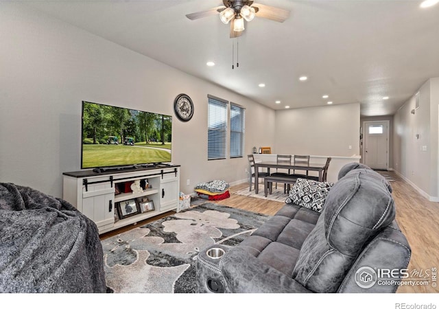 living room with light hardwood / wood-style floors and ceiling fan