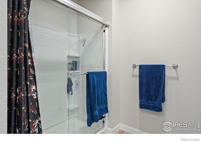 bathroom featuring a shower with shower door