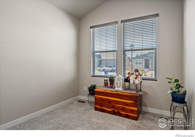 interior space with lofted ceiling and light carpet