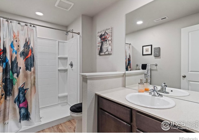 bathroom with vanity, a shower with curtain, toilet, and hardwood / wood-style flooring