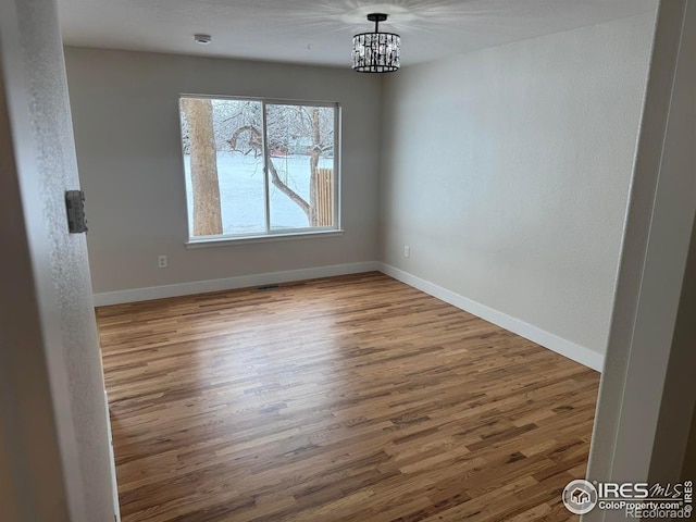 unfurnished dining area featuring hardwood / wood-style floors and an inviting chandelier