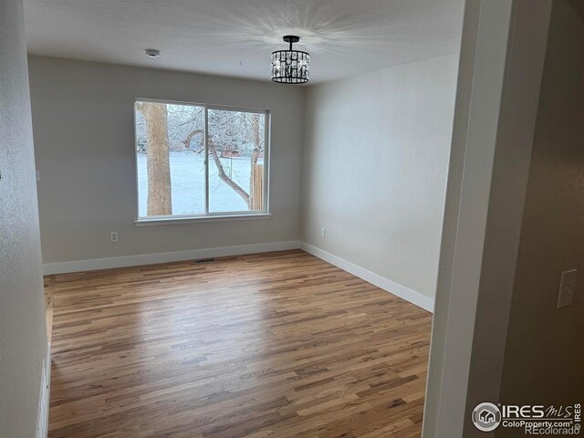 unfurnished dining area featuring hardwood / wood-style floors and a notable chandelier