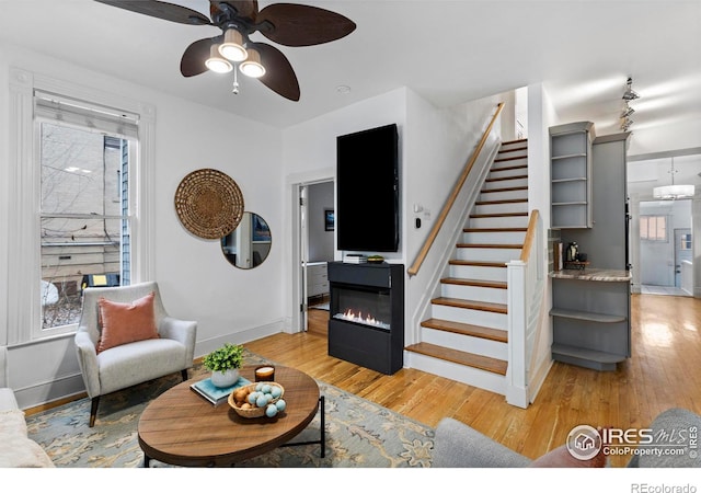 living room featuring ceiling fan and light hardwood / wood-style floors