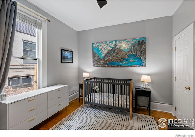 bedroom featuring a crib and dark wood-type flooring