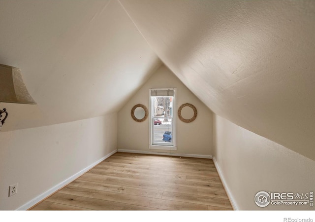 bonus room featuring vaulted ceiling and light hardwood / wood-style floors