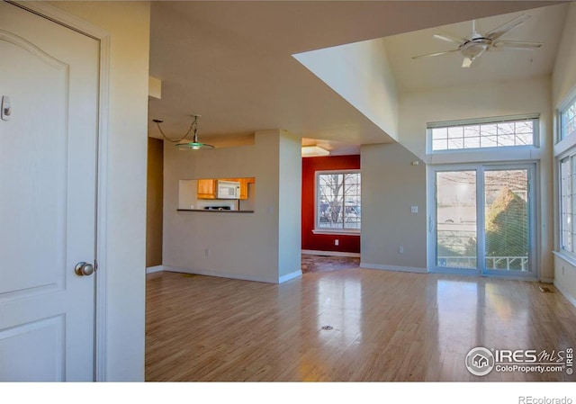 unfurnished living room featuring ceiling fan and light hardwood / wood-style floors