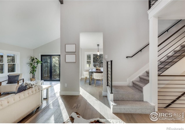 interior space featuring a towering ceiling and hardwood / wood-style flooring