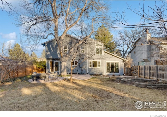 rear view of house with a lawn and a patio area