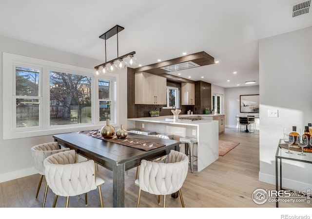 dining area with plenty of natural light and light hardwood / wood-style flooring