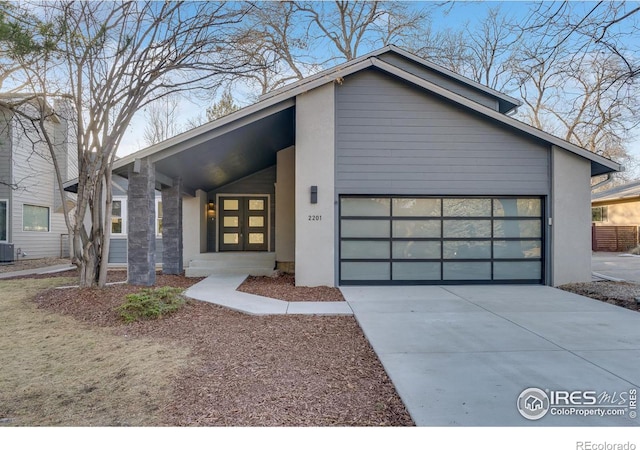 contemporary house with a garage, a carport, and central AC