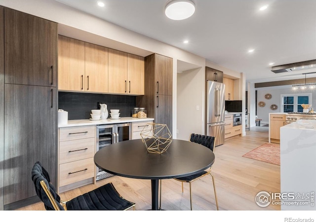 dining space featuring light hardwood / wood-style flooring and beverage cooler