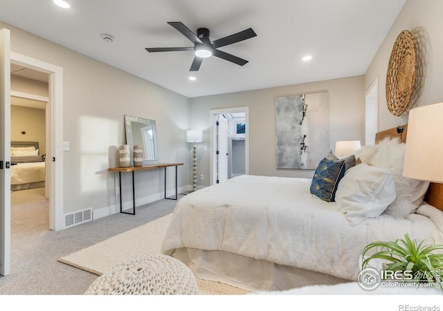 bedroom featuring ceiling fan, a spacious closet, and light carpet