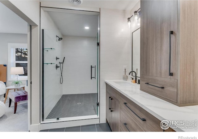 bathroom with vanity and a shower with door