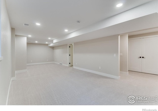 basement featuring light colored carpet