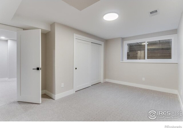 unfurnished bedroom featuring light colored carpet and a closet