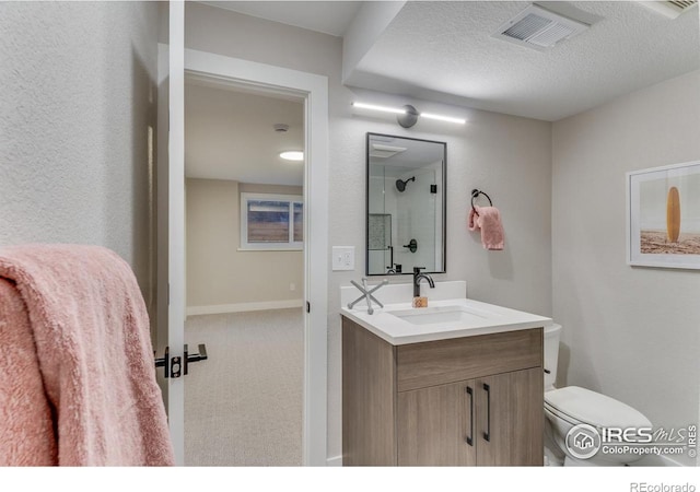 bathroom with vanity, a textured ceiling, and toilet