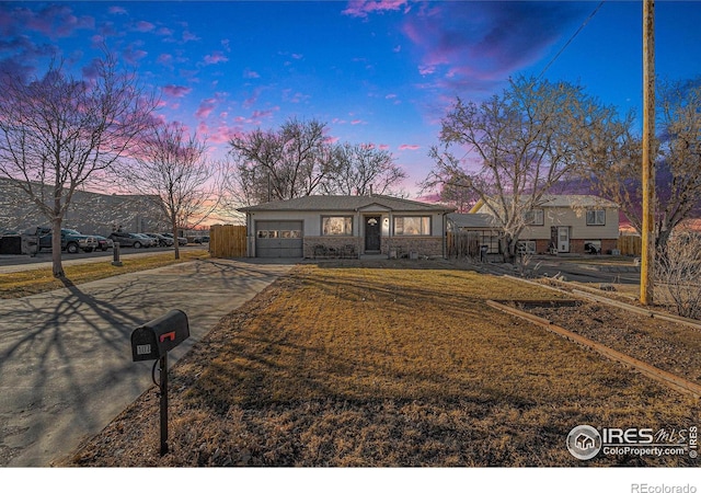 ranch-style house featuring a yard and a garage