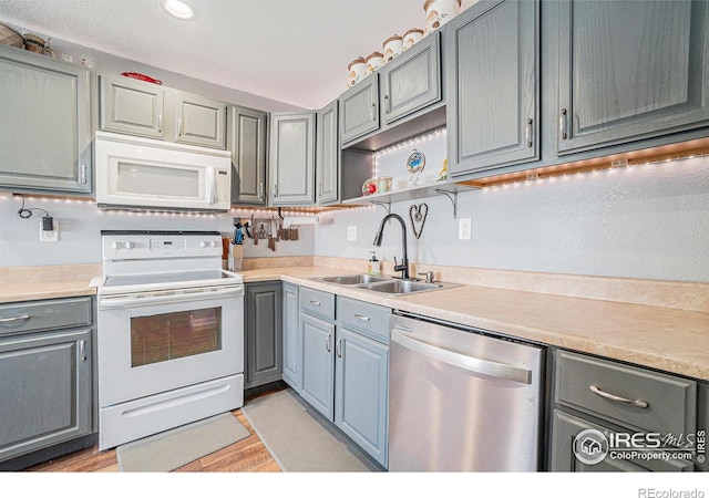 kitchen with sink, white appliances, and light hardwood / wood-style floors