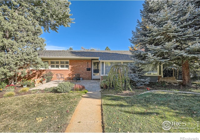 view of front of house with a patio area and a front lawn