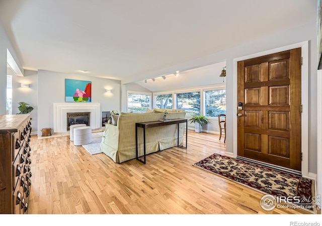 living room with vaulted ceiling and light wood-type flooring