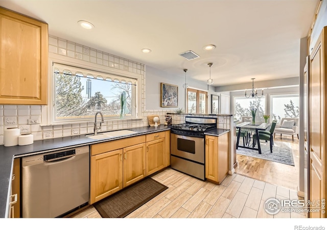 kitchen featuring pendant lighting, sink, backsplash, and stainless steel appliances