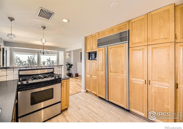 kitchen with a chandelier, pendant lighting, light brown cabinetry, and built in appliances