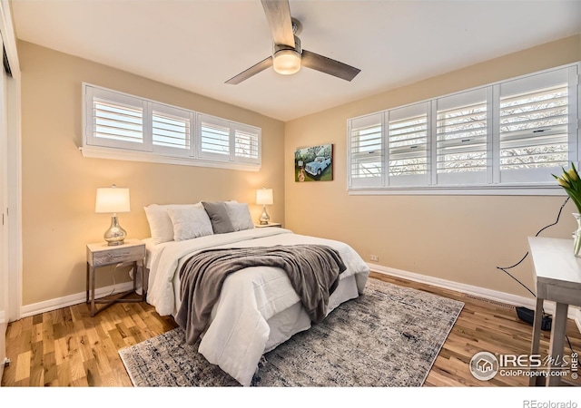 bedroom with ceiling fan, multiple windows, and light wood-type flooring