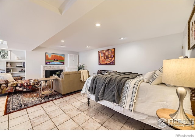 bedroom with a tiled fireplace and light tile patterned floors