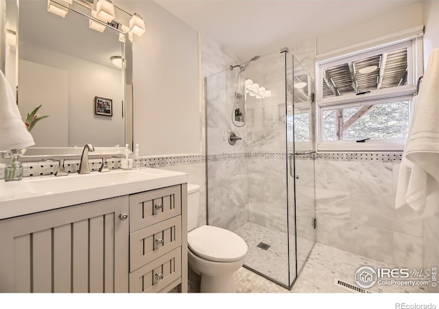 bathroom featuring an enclosed shower, vanity, and toilet