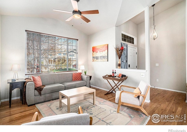 living room with a ceiling fan, baseboards, vaulted ceiling, and wood finished floors