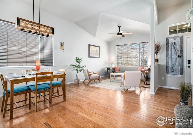 dining area featuring baseboards, light wood finished floors, ceiling fan, and lofted ceiling