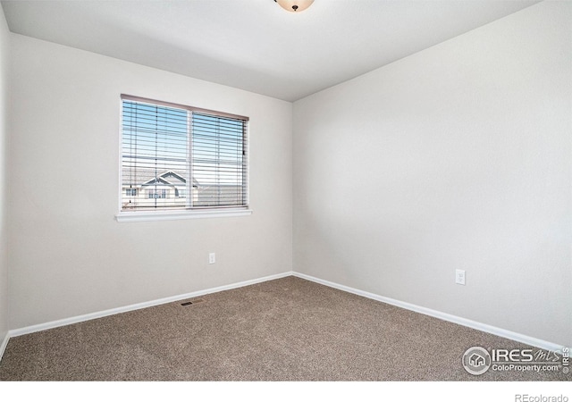 unfurnished room featuring baseboards, visible vents, and carpet