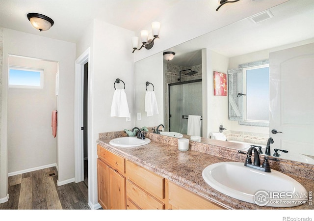 full bath featuring a shower stall, a sink, and wood finished floors