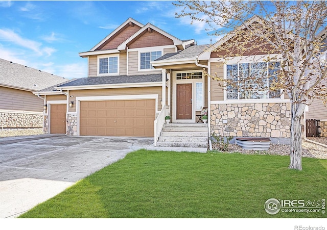 craftsman-style house with stone siding, a front yard, a shingled roof, an attached garage, and driveway