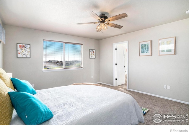 carpeted bedroom featuring baseboards, a ceiling fan, and ensuite bathroom