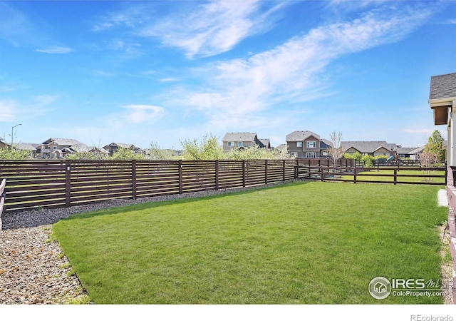 view of yard with a fenced backyard and a residential view