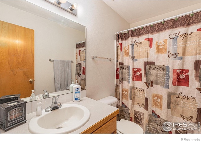 bathroom featuring walk in shower, vanity, and toilet