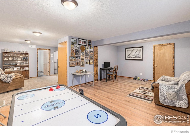 recreation room featuring hardwood / wood-style flooring and a textured ceiling