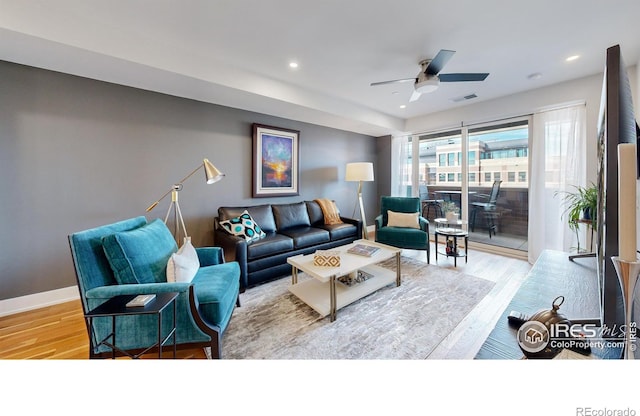 living room with ceiling fan and light wood-type flooring